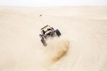 The rear view of a sand rail driving fast