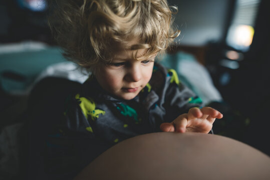 Playing with mom's belly button