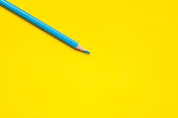 diagonal blue sharp wooden pencil on a bright yellow background, isolated, copy space, mock up.