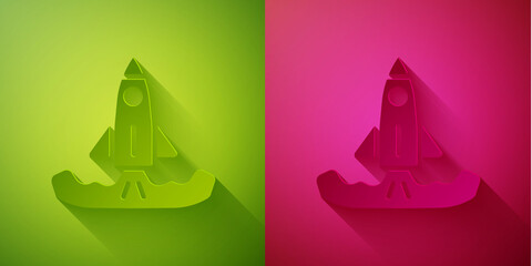 Paper cut Rocket icon isolated on green and pink background. Paper art style. Vector.