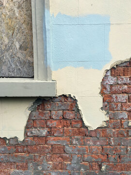 Brickwork of a derelict building with some render still in place.