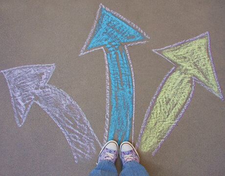 Feet standing at the intersection of three different arrows