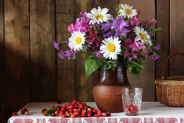 Obraz na płótnie Canvas bouquet of garden flowers and strawberries.