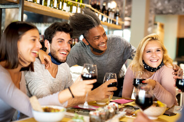 group of friends toasting with wine during dinner in a restaurant, multiethnic group have a fusion...