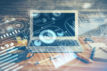 Computer on desktop in office with technology theme hologram. Double exposure. Tech concept.