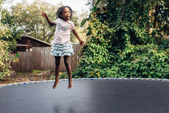 Black girl jumping on trampoline