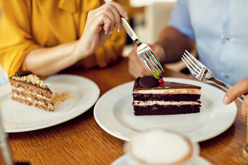 Close-up of couple sharing cake in a cafe
