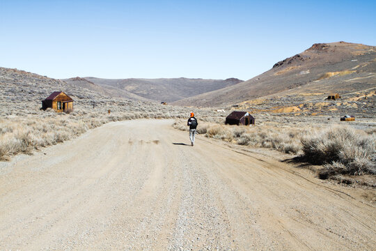 Man Walking Down Dirty Road in Ghost Town
