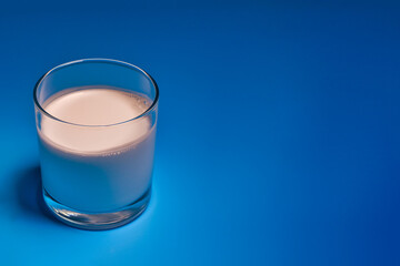 glass with milk on a blue background