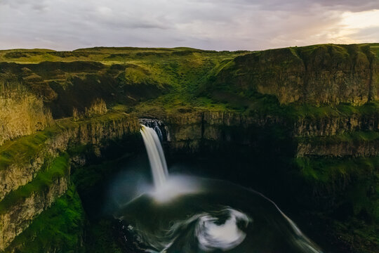 Nighttime Landscape View Of Waterfall And Canyon Under Cloudy Sky
