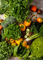 Fresh vegetables and greens with chopping board on the table. Close-up
