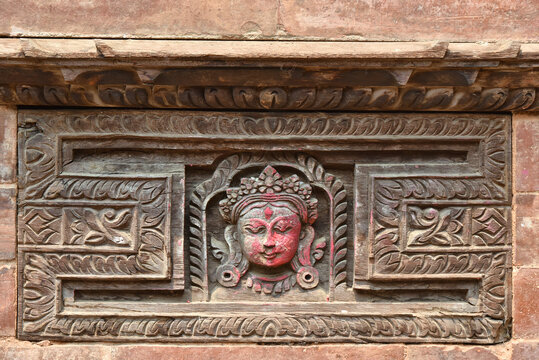 Detail of a face carved on wood in a nepali facade