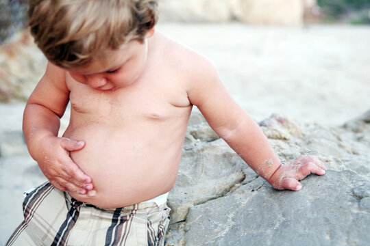 Toddler At Beach Touching His Bare Tummy