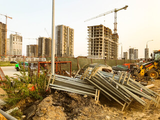 construction landscape. abandoned construction site. unnecessary building materials lie in the bushes. abandoned tall houses. unfinished quarter for human life