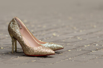 Goldene und glitzernde High Heels auf der Straße