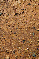 Moist yellow soil with lots of small stones, detailed texture