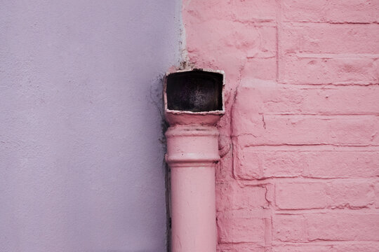 Pastel Purple and Pink Wall With a Pink Pipe on it