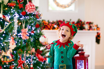 Child decorating Christmas tree. Kid on Xmas eve.