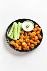 Cauliflower buffalo wings with celery and sauce