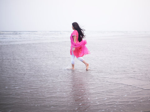 Indian woman walking alone in sea beach