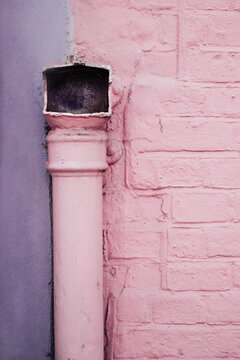 Pastel Purple and Pink Wall With a Pink Pipe on it