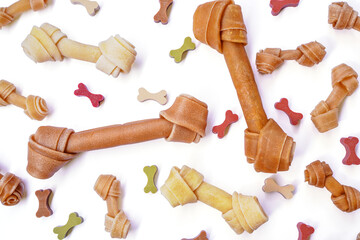 Top view of Dog knotted bone or rawhide and colorful dog snack in several sizes isolated on white background 