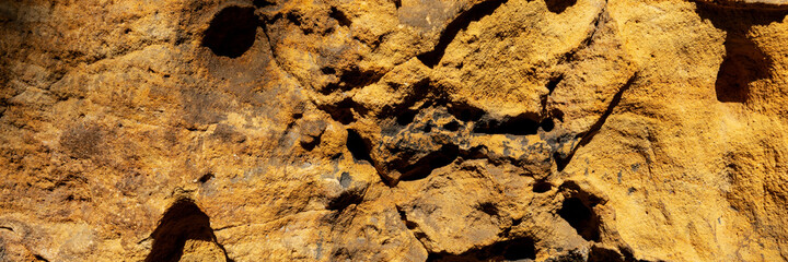 Sandstone panoramic background. Close-up of holey natural sandstone rocks