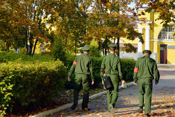 Obraz premium A three-man military patrol in the autumn city park.