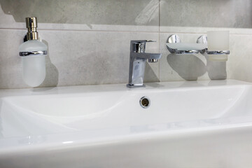 Ceramic Water tap sink with faucet with soap and shampoo dispensers in expensive loft bathroom or kitchen
