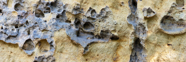 Sandstone panoramic background. Close-up of holey natural sandstone rocks