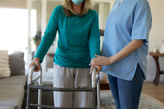 Mid section of senior woman and female health worker at home