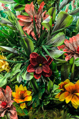 Elements and details of interior decor, home floriculture, original floral summer background pattern from artificial tropical exotic bright multicolored colorful flowers and plants with leaf texture