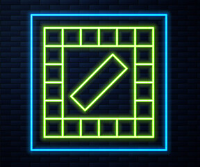 Glowing neon line Board game icon isolated on brick wall background. Vector.
