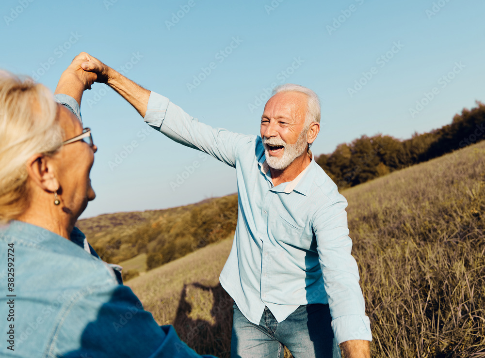 Wall mural woman man outdoor senior couple happy lifestyle retirement together smiling love dancing nature matu