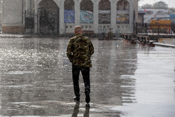 Young man walking on a rainy day