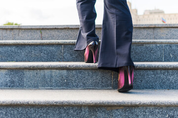 business woman climbs the stairs. Feet on the steps