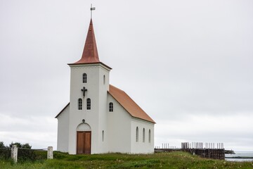Fototapeta na wymiar White Kollafjardarneskirkja Christian church at Western Iceland in cloudy weather