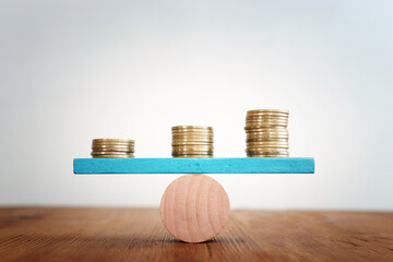 Stack of coins balance on seesaw