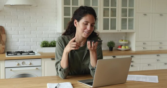 Happy 35s woman holding smartphone leave voice message using speaker phone. Smiling business woman talk to client on loud speaker enjoy modern wireless technology easy and comfort usage, ai concept