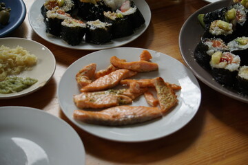 Grilled salmon and sushi in the background
