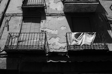 Old balconies in a black and white city with Spain flag