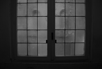 Closed window to inner courtyard in a city in black and white