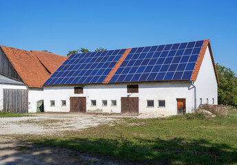 Green Energy with Solar Collectors on an agricultural building. Building modified by image editing.