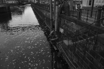 Dirty industrial canal in the city in black and white