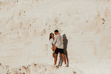 Beautiful couple on the white rocks. Happy couple hugging and smiling at summer sunny day.