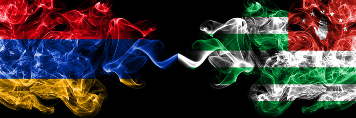 Armenia vs Abkhazia, Abkhazian smoky mystic flags placed side by side. Thick colored silky abstract smoke flags
