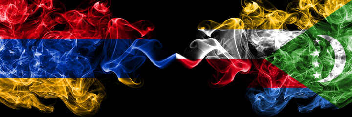 Armenia vs Comoros, Comorian smoky mystic flags placed side by side. Thick colored silky abstract smoke flags