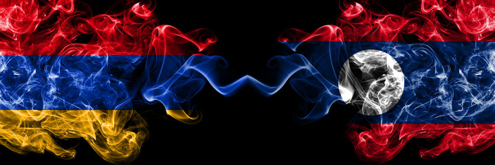 Armenia vs Laos smoky mystic flags placed side by side. Thick colored silky abstract smoke flags