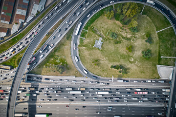Shot from above on big junction with curves, overpasses and exits. A lot of cars
