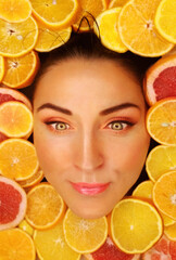 beautiful woman face around citrus fruits slices. funny emotion. close up